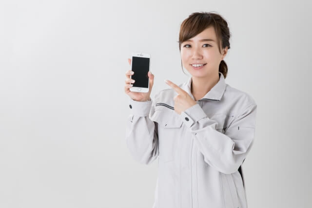 スマートフォンを指差す女性